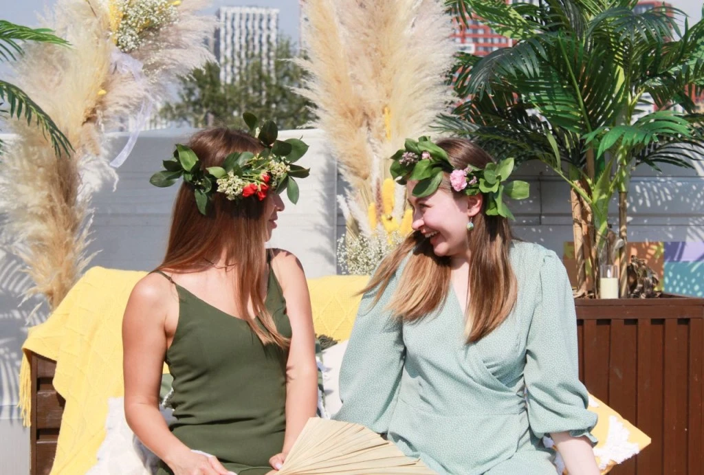 участницы Summer Design Day на крыше с цветочными венками и фотозоной